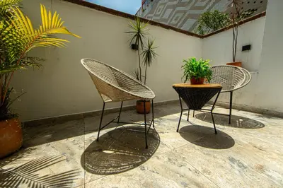 two chairs and a table in a patio with plants at La Martina Boutique Hotel in Medellín