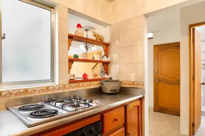 a kitchen with a stove top and a window at Casa Entera-Cerca a Mall La Central y Estación de Tranvía in Medellín