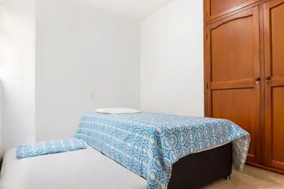 a bed with a blue blanket on top of it at Casa Entera-Cerca a Mall La Central y Estación de Tranvía in Medellín