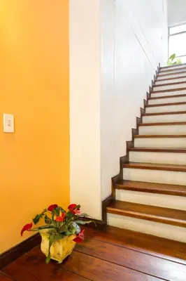 a vase of flowers sitting on the floor next to a staircase at Casa Entera-Cerca a Mall La Central y Estación de Tranvía in Medellín