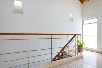 a staircase in a room with white walls and a window at Casa Entera-Cerca a Mall La Central y Estación de Tranvía in Medellín