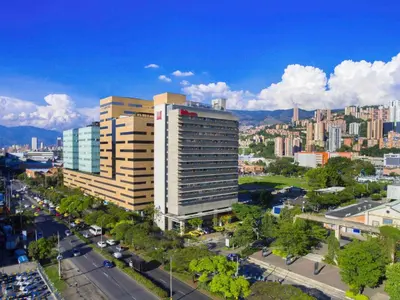 a tall building in a city with a street at ibis Medellin in Medellín