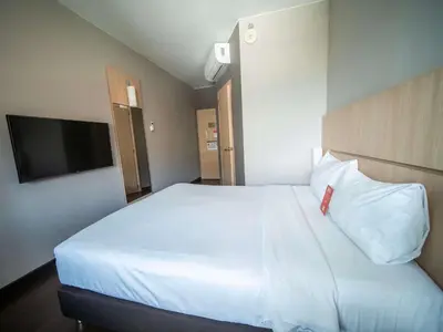 a bedroom with a large white bed with a red pillow at ibis Medellin in Medellín