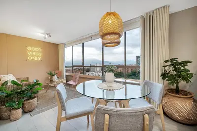 a dining room with a glass table and chairs at Aptos Alcazar Oviedo By HOUSY in Medellín