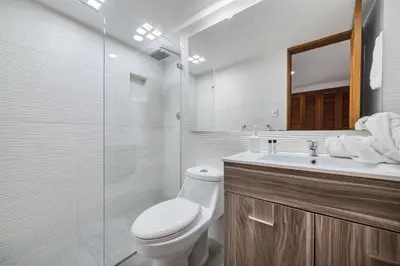 a bathroom with a toilet and a sink and a mirror at Aptos Alcazar Oviedo By HOUSY in Medellín