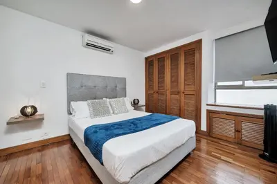 a bedroom with a large bed and a flat screen tv at Aptos Alcazar Oviedo By HOUSY in Medellín