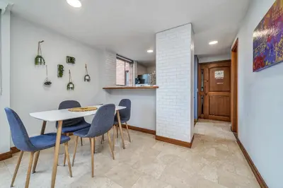 a dining room with a table and blue chairs at Aptos Alcazar Oviedo By HOUSY in Medellín