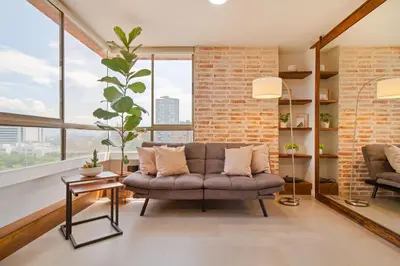 a living room with a couch and large windows at Aptos Alcazar Oviedo By HOUSY in Medellín