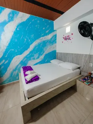 a bed in a room with a painting on the wall at Hotel Jireh - San Carlos Ant in San Carlos