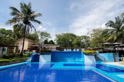 a pool at a resort with blue water and palm trees at Hotel el Tesoro in San Jerónimo
