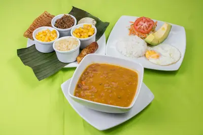 a table with two plates of food and a bowl of soup at Hotel el Tesoro in San Jerónimo