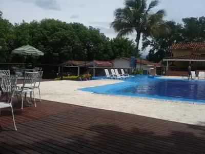 a swimming pool with chairs and a table and an umbrella at Hotel el Tesoro in San Jerónimo