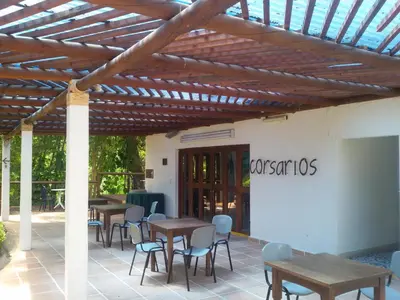 a patio with tables and chairs under a wooden pergola at Hotel el Tesoro in San Jerónimo