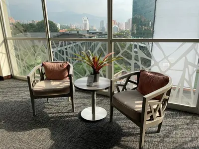 two chairs and a table in front of a window at Hotel bh El Poblado in Medellín