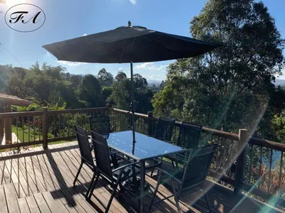 a table and chairs with an umbrella on a deck at Finca Alejandria in Guatapé