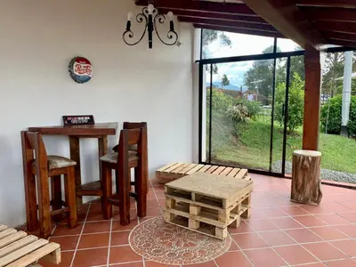 a room with a table and chairs and a table and a window at Finca Alejandria in Guatapé