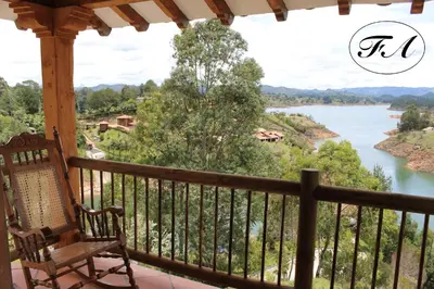 a porch with a bench and a view of a river at Finca Alejandria in Guatapé