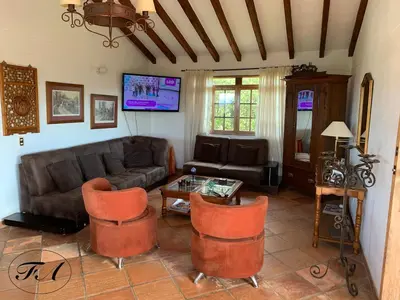 a living room with a couch and a table and chairs at Finca Alejandria in Guatapé