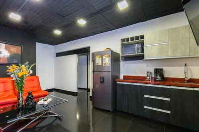 a kitchen with an orange chair and a refrigerator at Provenza Lofts in Medellín