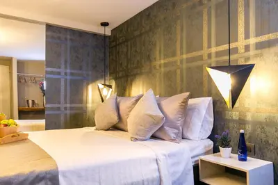 a bedroom with a large white bed and a table at Provenza Lofts in Medellín