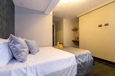 a bedroom with a white bed with blue pillows at Provenza Lofts in Medellín