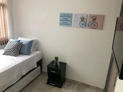 a bedroom with a bed and a table with a bike on the wall at Apartamentos View, calle del Malecón frente al lago in Guatapé