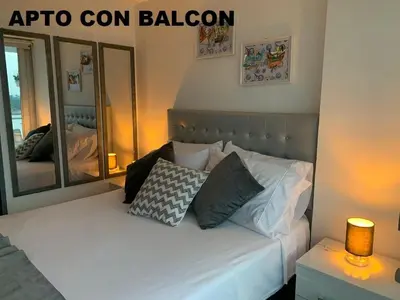 a bedroom with a white bed with a mirror at Apartamentos View, calle del Malecón frente al lago in Guatapé