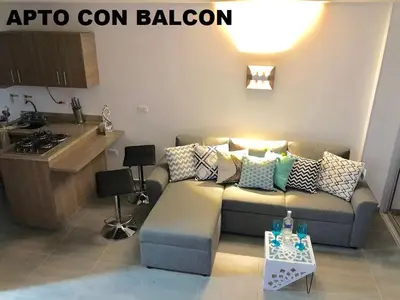 a living room with a couch and a kitchen at Apartamentos View, calle del Malecón frente al lago in Guatapé