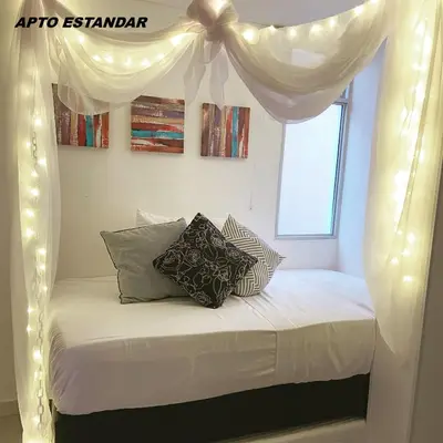 a bedroom with a canopy bed with lights at Apartamentos View, calle del Malecón frente al lago in Guatapé