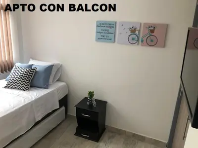a bedroom with a bed and a table with a bike on the wall at Apartamentos View, calle del Malecón frente al lago in Guatapé