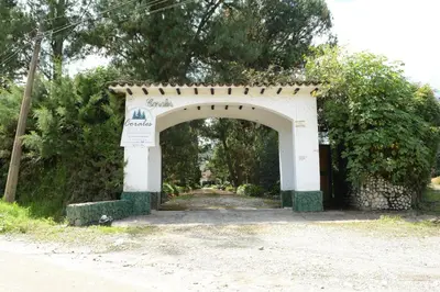 an archway with a sign in front of a road at Casa Finca Corales Llano Grande 2 in Rionegro