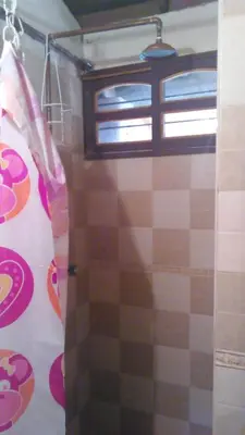 a shower curtain in a bathroom with a window at Hospedaje Rural Misia Emilia in Medellín