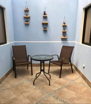 two chairs and a table in a room with shelves at Hotel Puerto Azul in Puerto Berrío