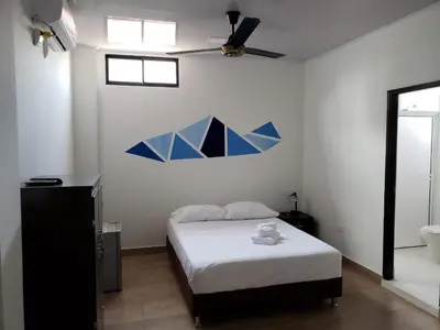 a bedroom with a bed and a ceiling fan at Hotel Puerto Azul in Puerto Berrío