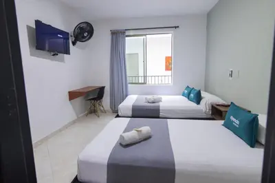 a hotel room with two beds and a television at Ayenda 1228 Balcones de la 70 in Medellín