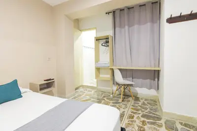 a bedroom with a bed and a chair and a window at Ayenda 1228 Balcones de la 70 in Medellín