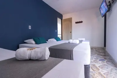 a room with two beds and a tv on the wall at Ayenda 1228 Balcones de la 70 in Medellín