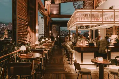 a restaurant with tables and chairs and a view of the city at The Click Clack Hotel Medellín in Medellín
