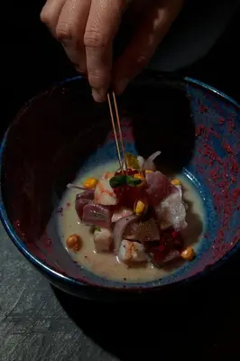 a person eating a bowl of soup with a pair of chopsticks at The Click Clack Hotel Medellín in Medellín