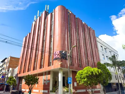 a large red building on a city street at Hotel Macedonia Plaza Medellin in Medellín