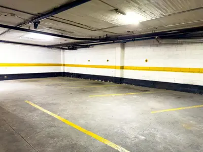 an empty parking garage with yellow and white walls at Hotel Macedonia Plaza Medellin in Medellín