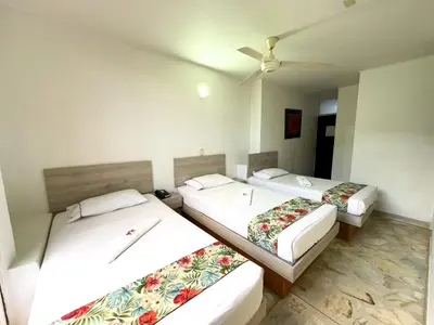 two beds in a room with a ceiling fan at Hotel Macedonia Plaza Medellin in Medellín