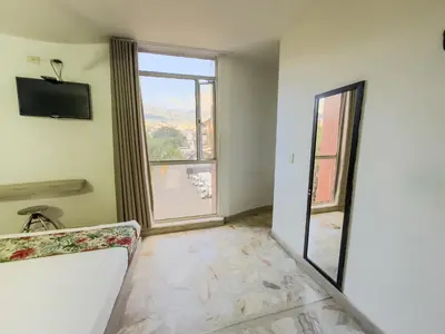 an empty room with a large window and a couch at Hotel Macedonia Plaza Medellin in Medellín