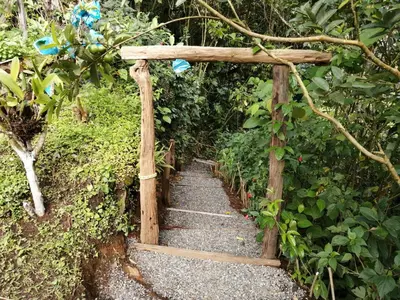 a path with a wooden arch in a garden at Cabaña Manantial del Turpial in Jardin
