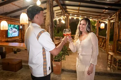 a man and a woman holding a glass of wine at Cabaña Manantial del Turpial in Jardin