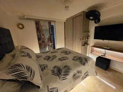 a bedroom with a bed with black and white pillows at Studio cerca a estacion metro poblado in Medellín