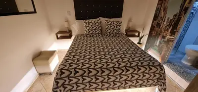 a bedroom with a bed with a black and white comforter at Studio cerca a estacion metro poblado in Medellín