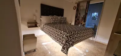 a bedroom with a bed with a black and white comforter at Studio cerca a estacion metro poblado in Medellín