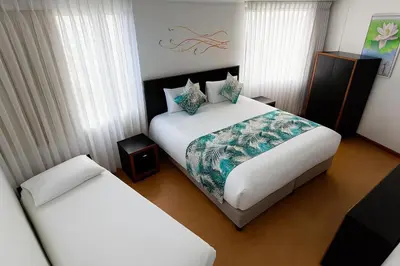 a hotel room with two beds in a room at Hotel Benidorm in Manizales