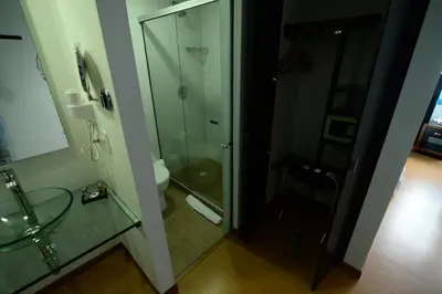 a bathroom with a glass shower and a toilet at Hotel Benidorm in Manizales